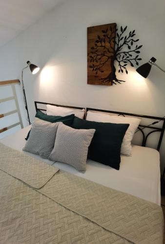 a bed with two lamps and two pillows on it at Zona Apartments 2 in Zrenjanin