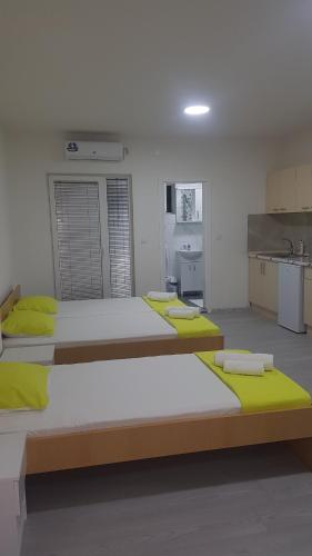 a room with three beds and a kitchen with a sink at Villa Sofijana in Ohrid