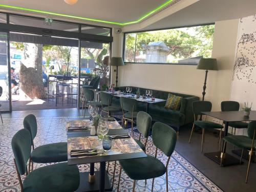 une salle à manger avec des tables et des chaises vertes dans l'établissement Hôtel La Villa d'Eze, à Èze