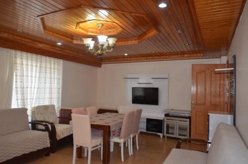 a living room with a table and a tv at Atalay Pansiyon in Harbiye