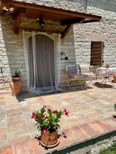 a patio with a table and a bench and flowers at B&B Il Poggetto in Serra SantʼAbbondio