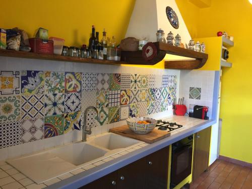 a kitchen with a sink and some tiles on the wall at Attico con Terrazza panoramica vista lago - LAKEHOLIDAY IT in Castel di Tora