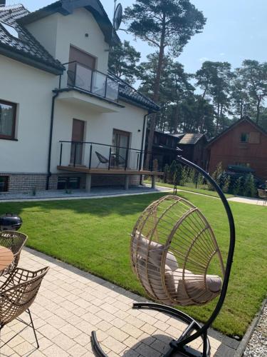 a chair sitting on a patio in front of a house at Na Wczasowej - Apartamenty in Międzywodzie