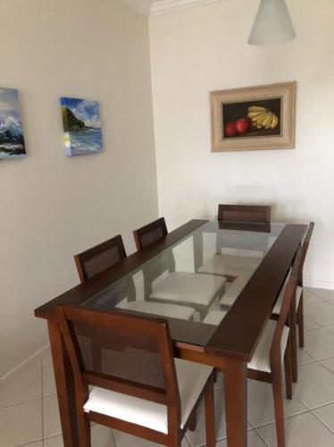 a dining room with a glass table and chairs at Villa Giardino - Condomínio de Frente para o Mar - Piscina, Quadra Esportiva, Churrasqueira - 5 Pessoas in Florianópolis