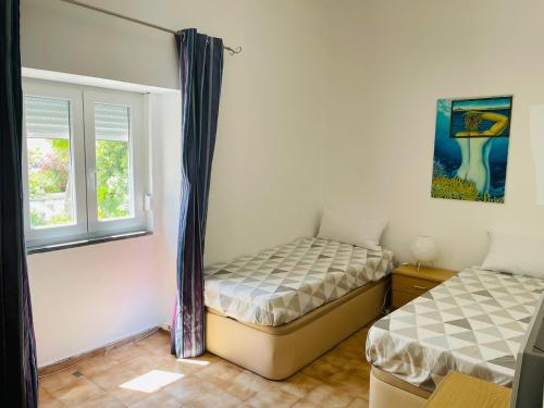 - une chambre avec 2 lits et une fenêtre dans l'établissement Casa da Avo, à Portimão