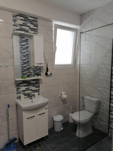a bathroom with a sink and a toilet and a window at Apartments Prima in Ohrid