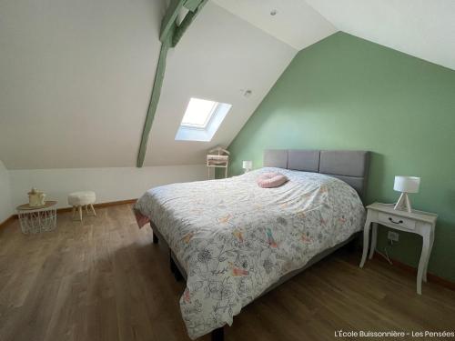 een slaapkamer met een groot bed op zolder bij L'École Buissonnière in Saint-Vigor-le-Grand