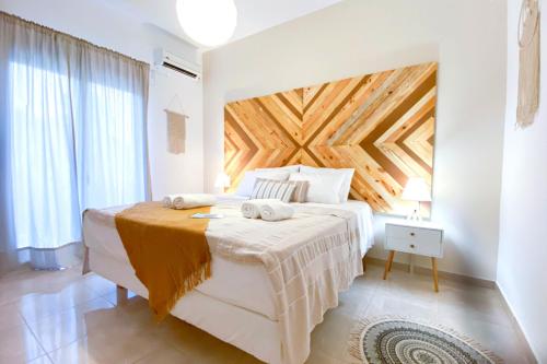 Summer Feel suites في بوروس: غرفة نوم بسرير كبير بسقف خشبي