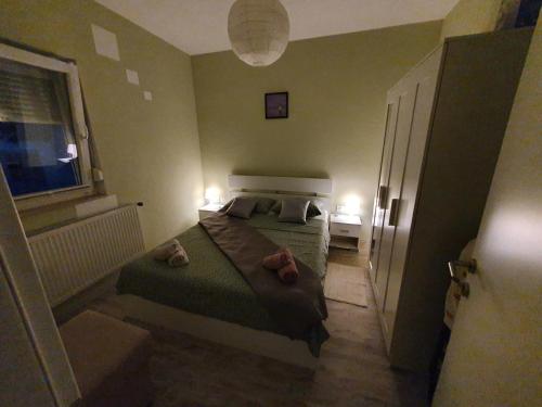 a small bedroom with a bed and a window at Apartman Luce in Krk