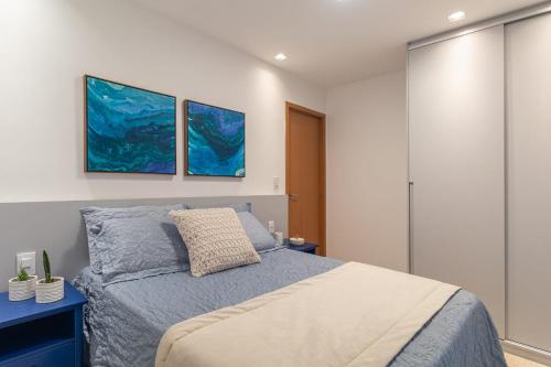 a bedroom with a bed and two paintings on the wall at Warung Praia Dos Carneiros in Praia dos Carneiros