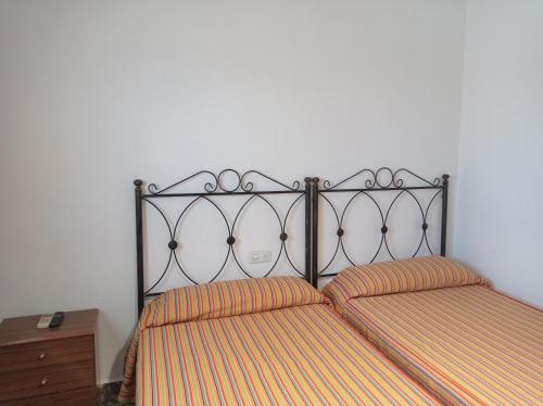 um quarto com 2 camas com lençóis de listras laranja em Antolin Guest House em Minaya