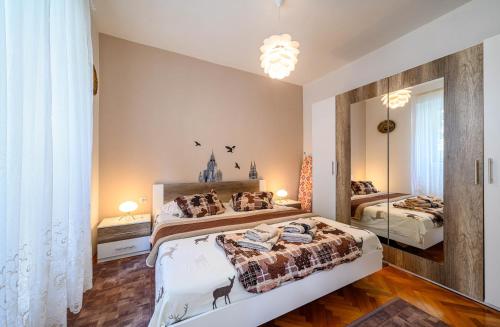 a bedroom with two beds and a large mirror at Apartment Dada in Šibenik
