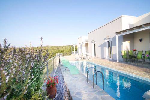 a house with a swimming pool next to a building at Iperion Apartment G2-2 in Agia Triada