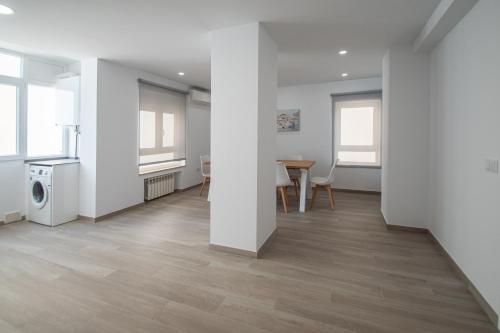 ein Wohnzimmer mit weißen Wänden sowie einem Tisch und Stühlen in der Unterkunft Nuevo Mirandilla Apartment - Cadiz Beach in Cádiz