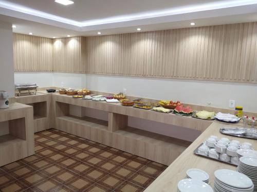 a buffet line in a restaurant with plates of food at Hotel Santa Clara in Caldas Novas