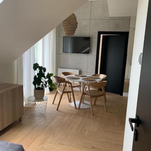 salon ze stołem jadalnym i krzesłami w obiekcie Na Wczasowej - Apartamenty w mieście Międzywodzie
