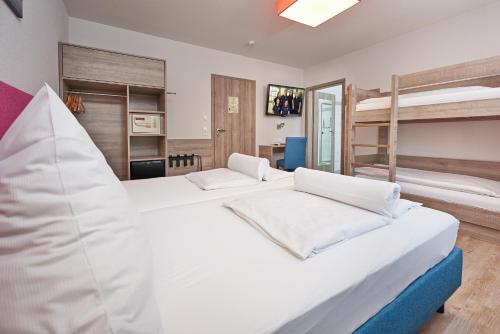 two beds in a room with two bunk beds at Gästehaus Mythos in Rust