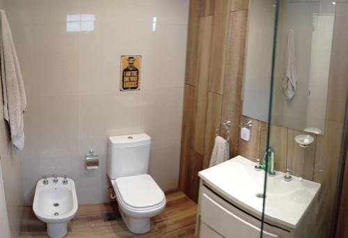 a white bathroom with a toilet and a sink at Buona Notte! in Bahía Blanca