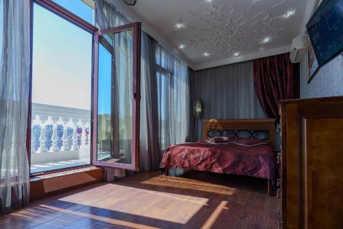 a bedroom with a bed and a large window at Gefest Apartments in Odesa