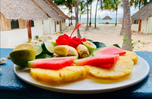 a plate of food on a table at Bwejuu Beach Palm Villa in Bwejuu