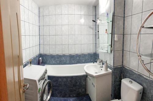 La salle de bains est pourvue d'une baignoire, de toilettes et d'un lavabo. dans l'établissement Apartament Zarnesti „Saturn”, à Zărneşti