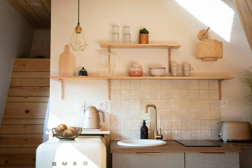 La cuisine est équipée d'un évier et d'un réfrigérateur. dans l'établissement Bain de forêt - Lodges Cosy & Spa, à Neufchâtel-Hardelot