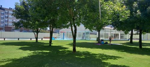 a group of people sitting in a park with trees at Apartamento Exterior Camino Inglés # a 10 min de Santiago in Sigüeiro