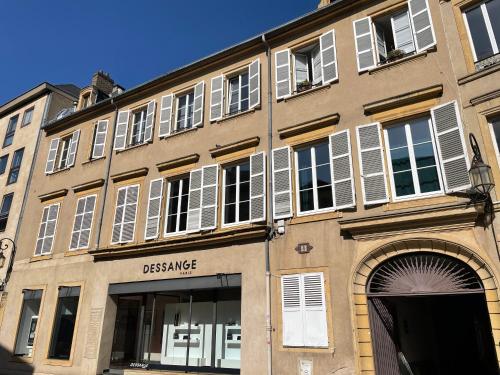 um grande edifício com persianas brancas em Hotel de Fouquet - Chambres d'hôtes em Metz