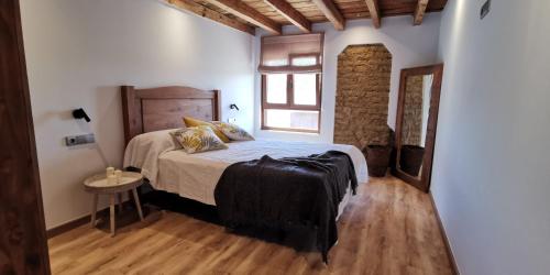 a bedroom with a bed and a wooden floor at Casa Rural Nogalia in Villanueva de los Nabos