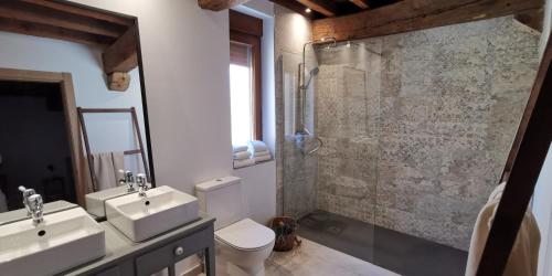 a bathroom with a toilet and a sink and a shower at Casa Rural Nogalia in Villanueva de los Nabos