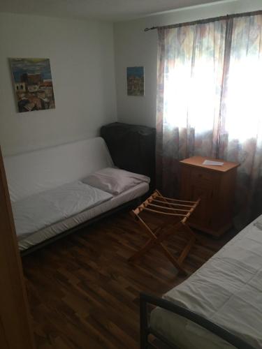 um quarto com uma cama, uma secretária e uma janela em Apartment em Reutlingen
