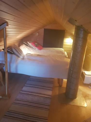 a bed in a room with a wooden ceiling at Villa Myklebostad in Breidvika
