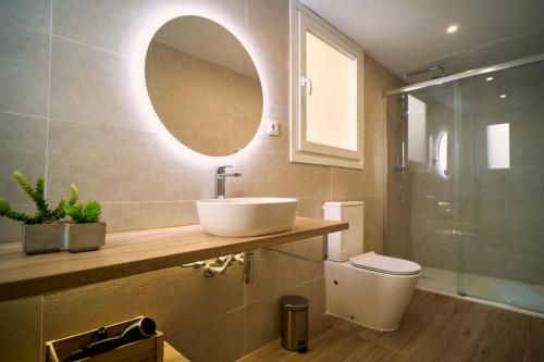 uma casa de banho com um lavatório, um WC e um espelho. em TeruelHOME III em Teruel