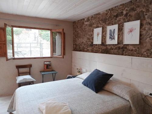 1 dormitorio con cama y ventana en Mas Violella allotjament rural en Sant Joan les Fonts