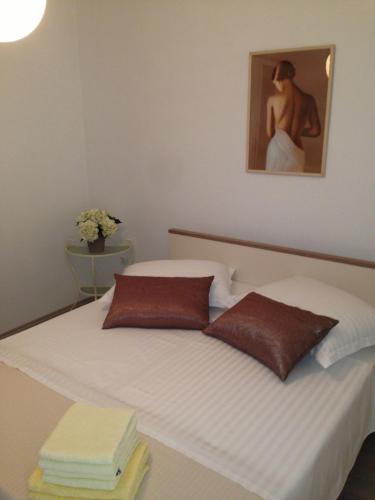 un letto con due cuscini e un dipinto sul muro di Apartman Slavko a Pridraga