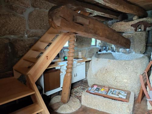 an attic room with a wooden ladder and a kitchen at Lagar da Silveira in Penafiel