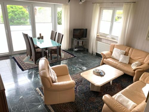 ein Wohnzimmer mit einem Sofa, Stühlen und einem Tisch in der Unterkunft Lüttje Huus Frieda mit Strandkorb am Strand von Mai bis September in Cuxhaven