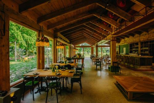 a restaurant with wooden tables and chairs and windows at Nekresi Estate in Kvareli