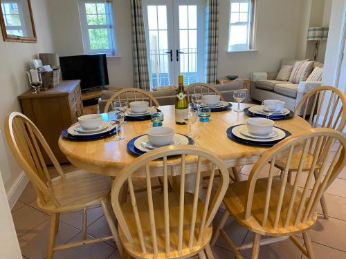 a dining room table with chairs and a bottle of wine at Cladach in Garlieston