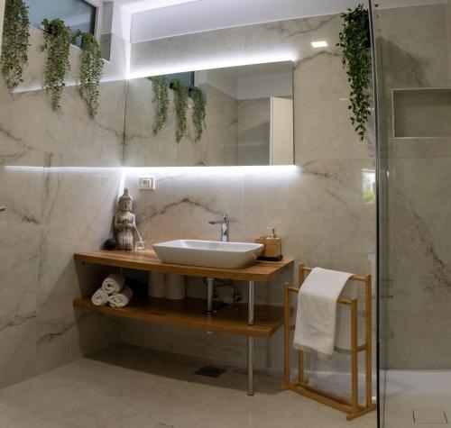 La salle de bains est pourvue d'un lavabo et d'un miroir. dans l'établissement Apartmaji na placu, à Renče