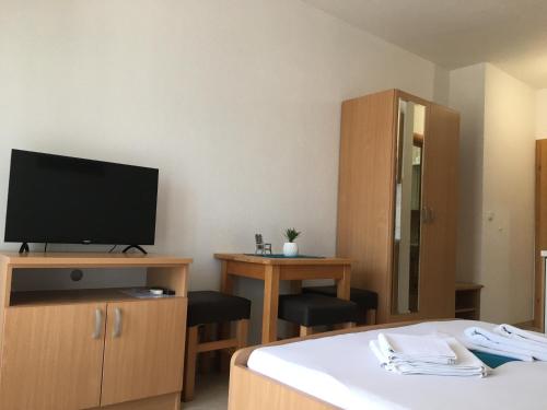 a hotel room with a bed and a television at Apartments MAMPAS in Neum