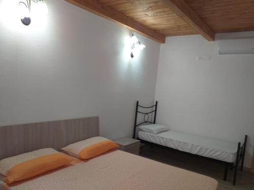Habitación con 2 camas, paredes blancas y techos de madera. en Il Mandorleto 2, en Cirò Marina