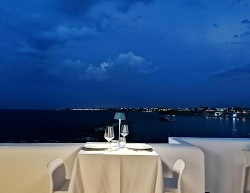 a table with two wine glasses and a view of the ocean at La Bella Trani - Suites and B&B in Trani