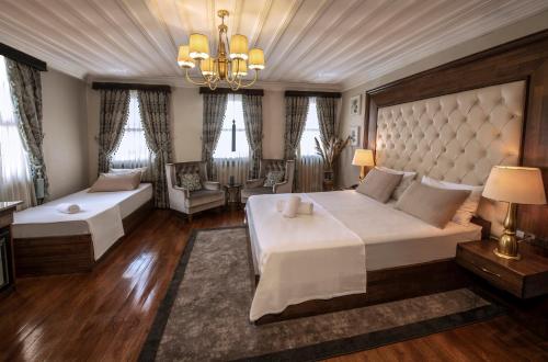 a large bedroom with two beds and a chandelier at Mezzo Hotel in Istanbul