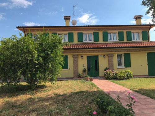 une maison avec de la peinture verte et jaune dans l'établissement Podere Baratta agriturismo e cantina, à Collinello
