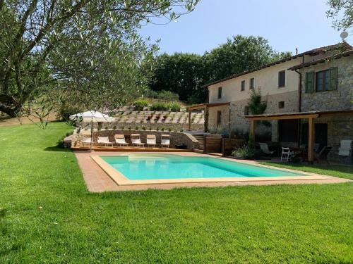 una piscina in un cortile accanto a una casa di Tenuta Gambit Agriturismo Umbria a Monteleone dʼOrvieto