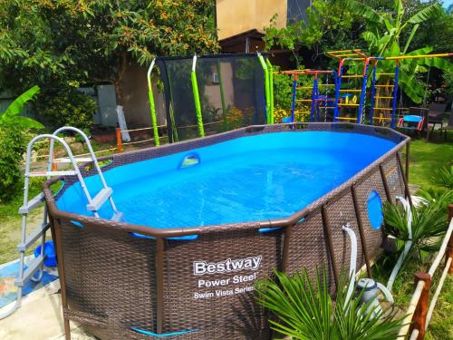 una gran piscina con un parque infantil en un patio en Guest house Lev en Pizunda