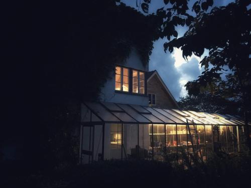 uma casa iluminada à noite com luzes nas janelas em Gladeholm em Kivik