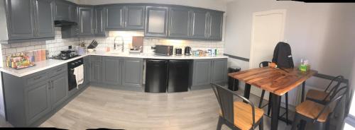 a kitchen with gray cabinets and a wooden floor at Heritage Holiday Accommodation in Pembrokeshire