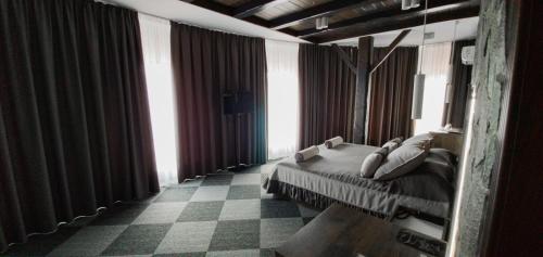 a person laying on a bed in a room with windows at Pidkova in Rivne
